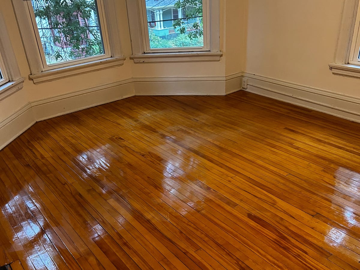Freshly cleaned hardwood floor in a bay window living room